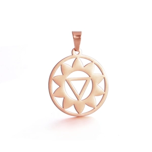 Détail macro d'un pendentif de yoga chakra circulaire en acier inoxydable couleur or rose