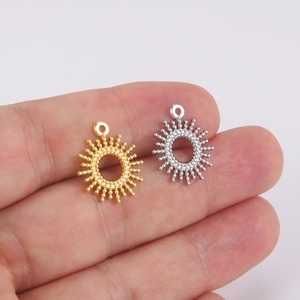 Handheld view of gold and silver starburst pendants in 304 stainless steel