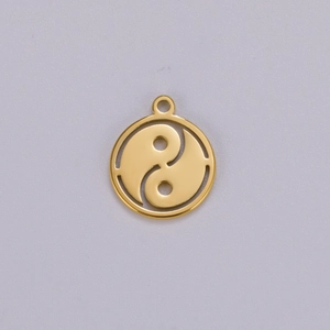 Macro view of golden stainless steel Tai Chi Yin Yang pendant with cut-out detail
