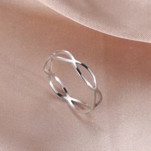 Detailopname van een zilveren titanium infinity ring op een luxe satijnen achtergrond