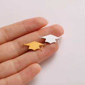 Macro view of gold and silver graduation cap charms for DIY jewelry making