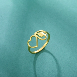 Close-up of golden interlocking heart ring featuring hollow and solid metal designs