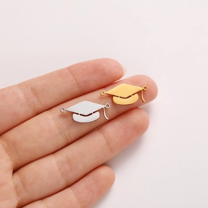 Macro detail of gold and silver graduation cap pendants for DIY jewelry making