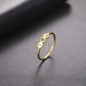 Macro view of gold stainless steel ring with circular hollow cutouts on textured background