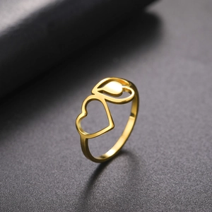 Macro detail of intertwined golden hollow heart titanium steel rings on leather