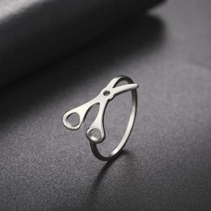 Anillo de tijeras minimalista de acero inoxidable plateado con acabado pulido y fondo oscuro
