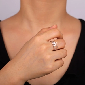 Detail shot of a silver hollow double-heart ring made of titanium steel on fingers