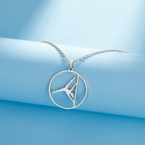 Dettaglio della collana con ciondolo silhouette di ginnasta su un supporto blu elegante