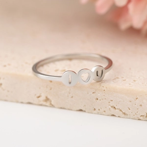Detailed shot of silver I Love You ring with heart cutout on natural stone base