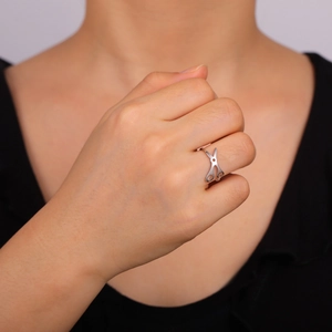 Anillo único de tijera en acero inoxidable plateado mostrado en el dedo de una modelo