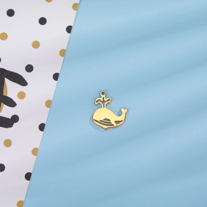 Pendentif baleine ajouré doré avec jet d'eau sur fond bleu et à motifs de pois