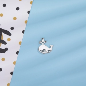 Détail du pendentif baleine argenté avec design ajouré et jet d'eau sculpté