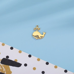 Vue détaillée d'un pendentif baleine dorée avec un design délicat de lignes ajourées