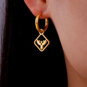 Macro shot of gold stainless steel huggie earring with phoenix motif in square frame