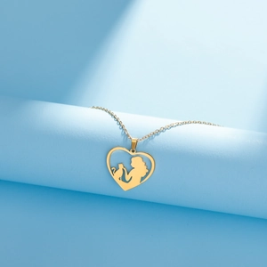 Detail of gold heart pendant with woman and cat silhouette on a blue pedestal