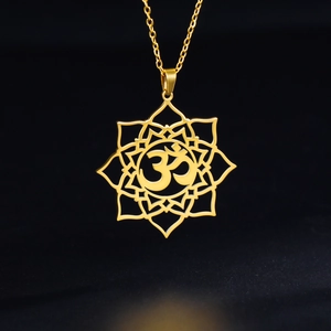 Golden lotus pendant necklace with carved Om symbol on a sleek black background