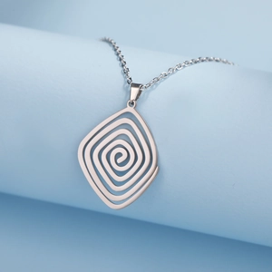 Macro shot of silver spiral pendant necklace with geometric rhodium finish textures