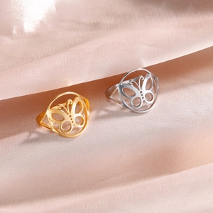 Polierte Schmetterlingsringe aus Edelstahl in Gold und Silber auf weichem Satin