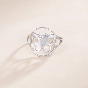 Minimalistischer hohl geschnittener Schmetterlingsring aus Edelstahl in Silber auf Beige