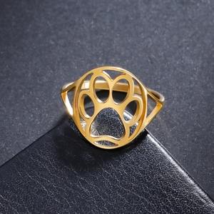 Macro detail of gold-plated stainless steel hollow cat paw print ring on black leather