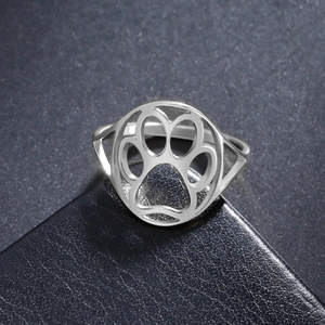 Sleek stainless steel ring with hollow cat paw design on black leather background