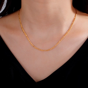 Primer plano de collar de cadena Figaro dorada en el cuello con eslabones pulidos