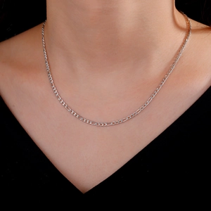 Detalle de un collar de cadena Figaro de acero inoxidable plateado usado por un modelo