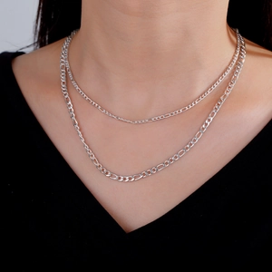 Primer plano de collar de doble cadena Figaro plateada para hombre con acabado pulido