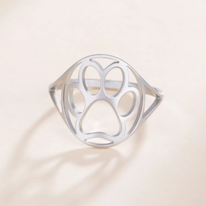 Close-up of a silver stainless steel ring featuring minimalist hollowed animal paw cutouts