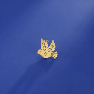 Artistic 18K gold plated hollow bird pendant on a textured dark blue background
