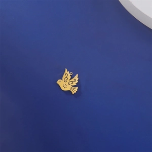 Detailed close-up of 18K gold-plated bird charm with intricate hollow floral patterns