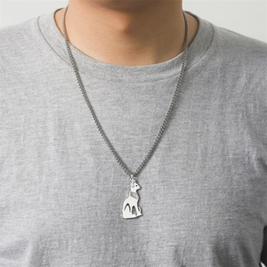 Detail of silver Egyptian Bastet cat pendant on a grey t-shirt showing the scale