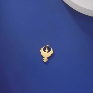 Detailed view of a polished 18K gold phoenix pendant on a navy textured background