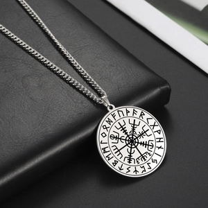 Retro Viking compass necklace with runes circular pendant on black leather surface