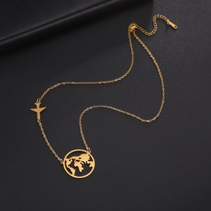 Detail of gold world map necklace with airplane charm on black leather background