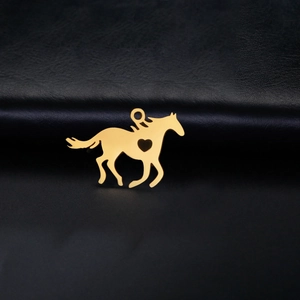 Polished gold stainless steel running horse pendant with heart cutout on leather surface