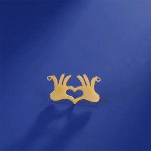 Detailed macro shot of a polished gold heart-shaped hand gesture charm for DIY jewelry