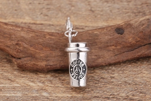 Macro shot of silver coffee cup pendant with lobster clasp on a rustic wood background