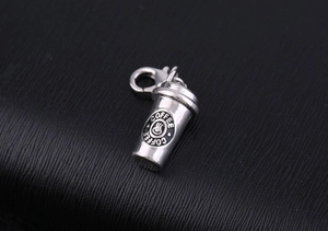 Macro shot of silver coffee cup pendant with lobster clasp on black leather background
