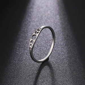 Detalle de anillo de acero inoxidable plateado con recortes huecos de fases lunares