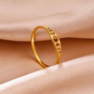 Anillo de acero inoxidable dorado con fases lunares caladas sobre fondo de seda