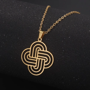 Macro view of golden Celtic knot pendant on a cross chain against black background