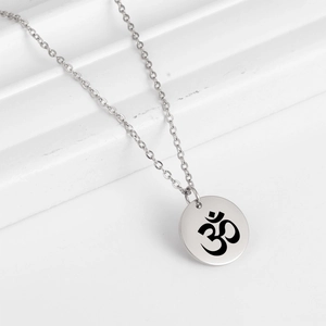 Détail du pendentif rond en acier inoxydable argenté avec symbole Om gravé au laser