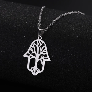 Detailed view of a silver stainless steel Hamsa hand necklace with a tree of life cutout