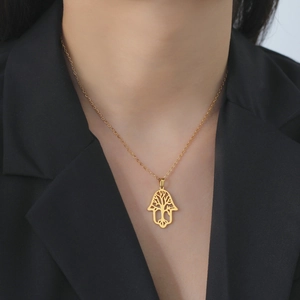 Golden stainless steel Tree of Life Hamsa pendant necklace worn on a model