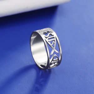 Macro shot of stainless steel ring featuring cutout Jesus text and fish symbol