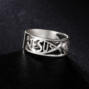 Macro shot of silver stainless steel Jesus ring with religious ichthys fish cutouts