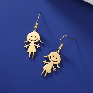 Detail of golden cartoon girl drop earrings with pigtails on dark blue backdrop