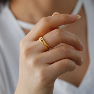 Matgouden roestvrijstalen knuffelring met minimalistisch armontwerp aan de vinger