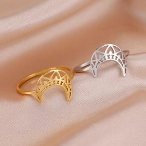 Polished titanium steel crescent moon rings with geometric mandala pattern on satin fabric
